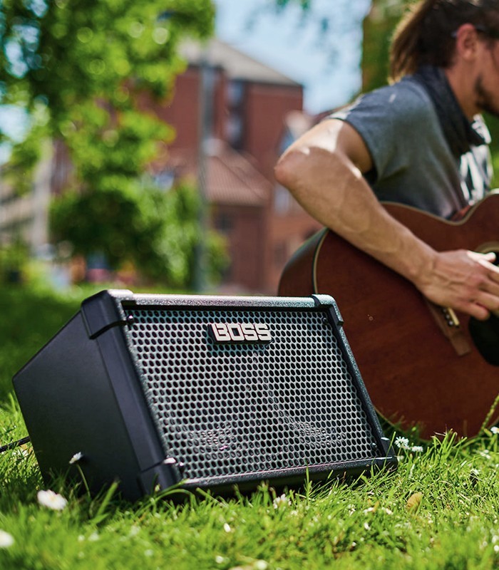 Amplifier Boss model Cube Street II for guitar on a park resting on  grass