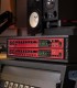 Focusrite Clarett+ OctoPre e 8Pre montados em rack num estúdio, com medidores LED e monitores visíveis.